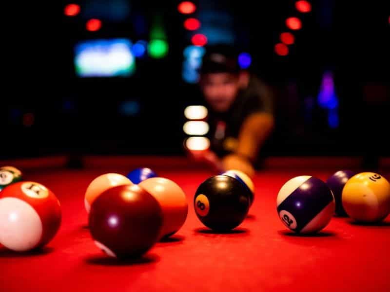 A man plays pool in a sports bar.