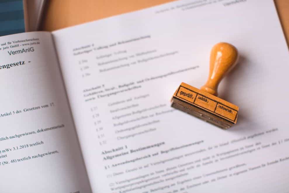 A brown rubber stamp placed on top of out-of-focus documents.